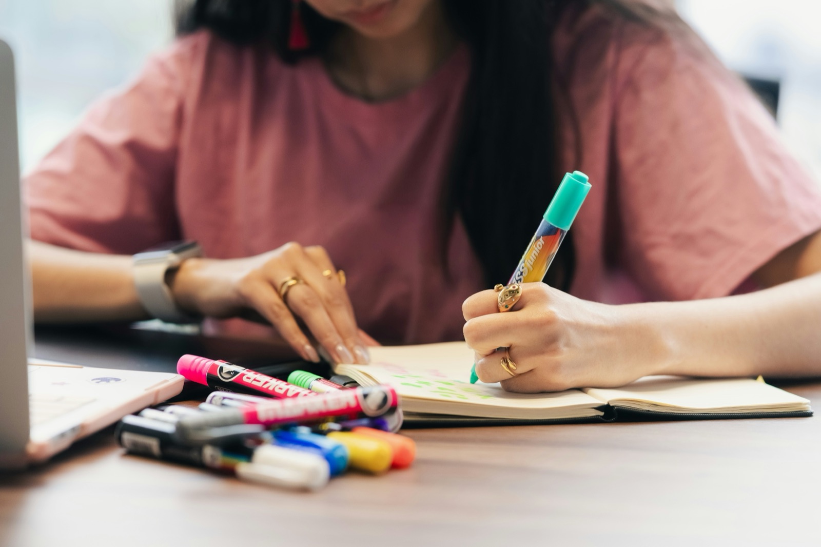 Eine Person lernt allein Deutsch am Schreibtisch mit Notizen und Laptop